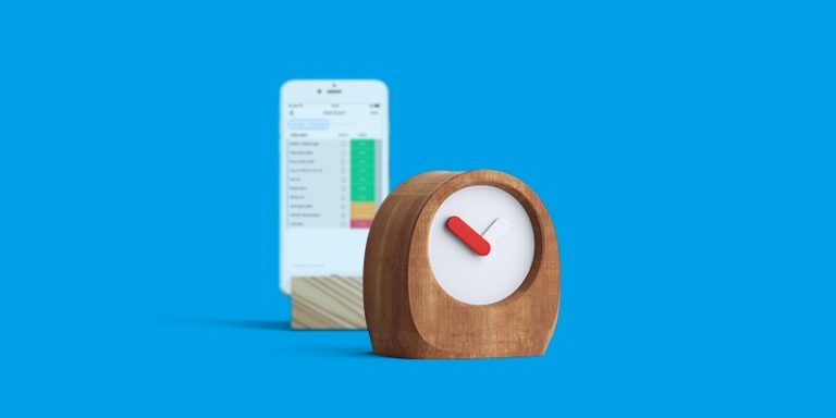 blue background with a phone showing a staging-mondaycomblog.kinsta.cloud board, and a wooden clock