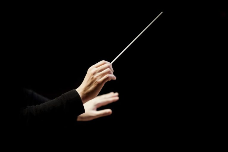 mains de chef d'orchestre baguette en main